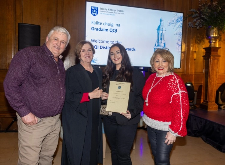 Four people pose with a certificate