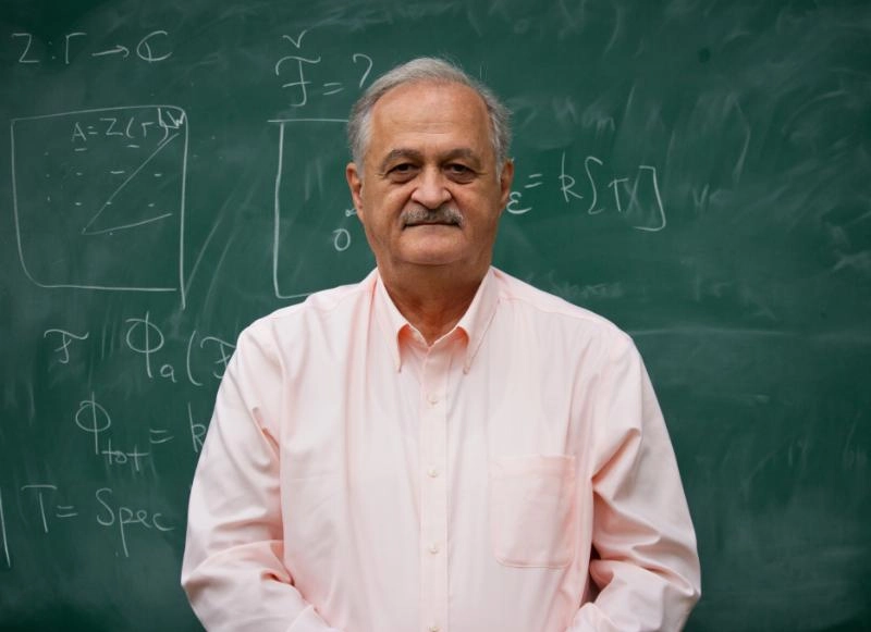 Prof. Samson Shatashvili in front of a teaching board with equations written on.