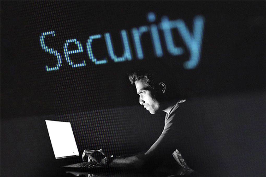 Man starting at laptop and word security above his head