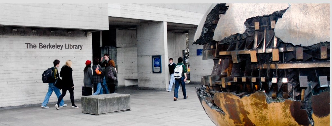 Students walking outside the Berkeley Library with the bronze sculpture 'Sfera con Sfera' on the right hand side.