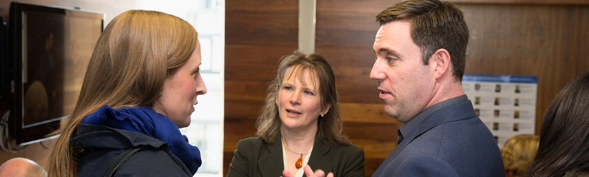 Two women and man chatting in conference room