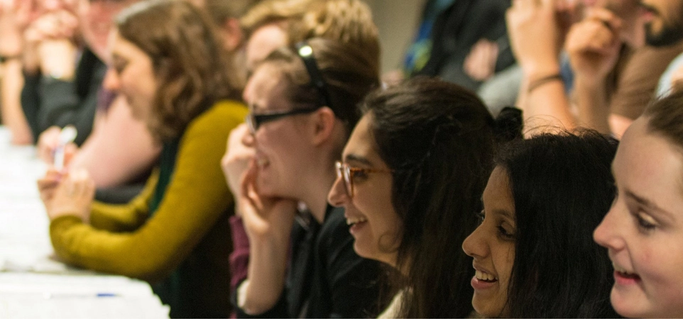 Image of women in Physics with young women students in a lecture hall