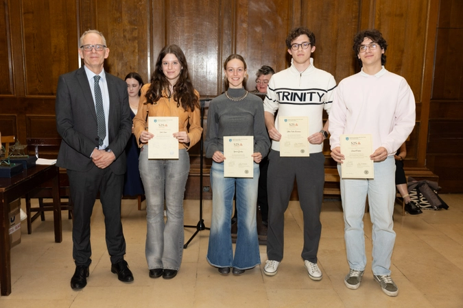 man in suit standing beside four volunteers, all holding certificates