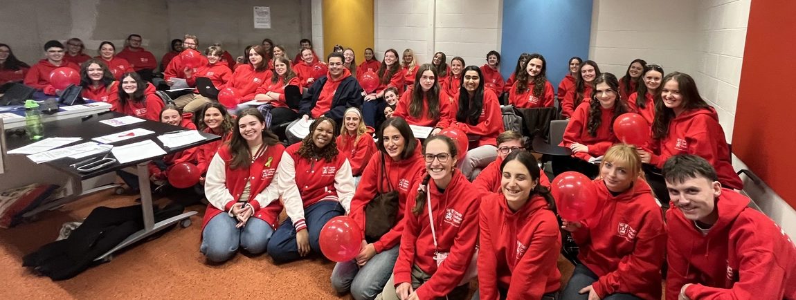 volunteers wearing red hoodies and smiling