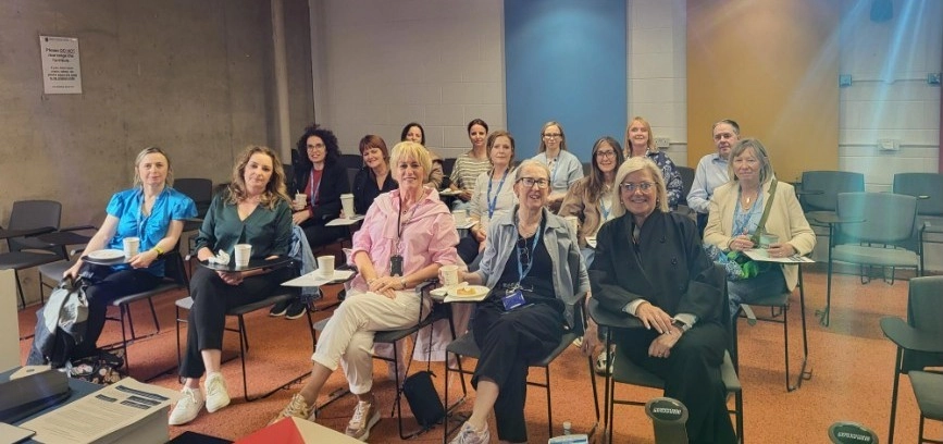 Three rows of people sitting in chairs at a seminar event