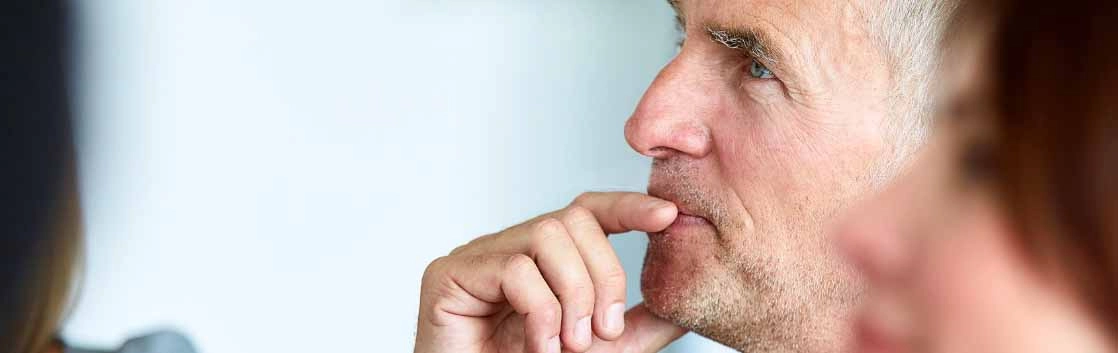 Man touching hand to lip in listening pose