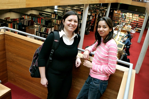 Two students standing in the library