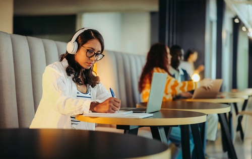 Student with headset taking notes