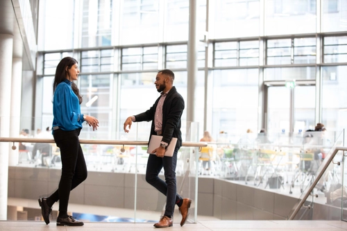 Two MBA students talking by the stairs