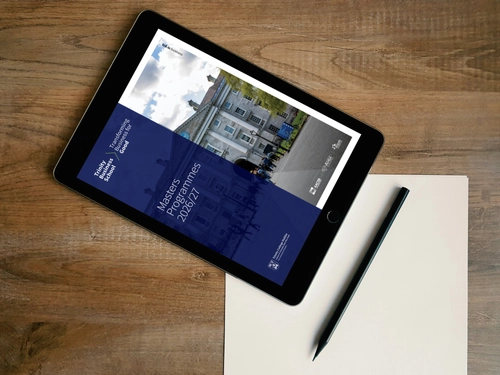An Ipad on a table with a note book