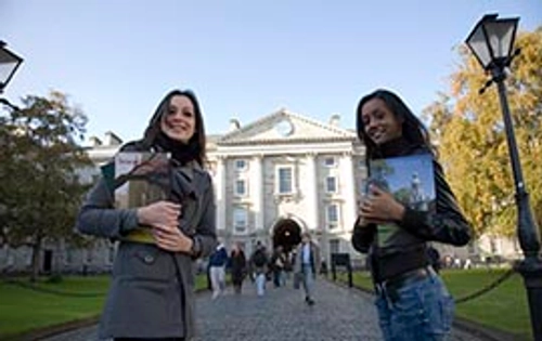 Two students standing at the front square of Trinity College Dublin
