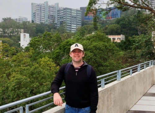 Daryl Egan standing against a background of the Hong Kong skyline