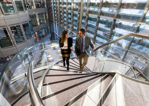 Students walk up Trinity Business School Spiral stairs.