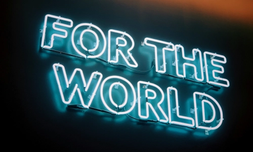 An image of a neon sign saying FOR THE WORLD
