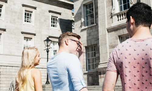 Three students walking up steps in Trinity College Dublin
