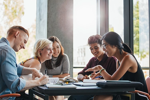Postgraduate Students collaborating around a desk