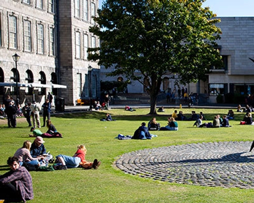 Students sitting in the sun in the grounds of Trinity College Dublin