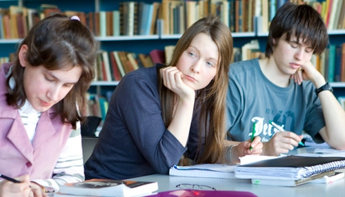 three students studying in the library