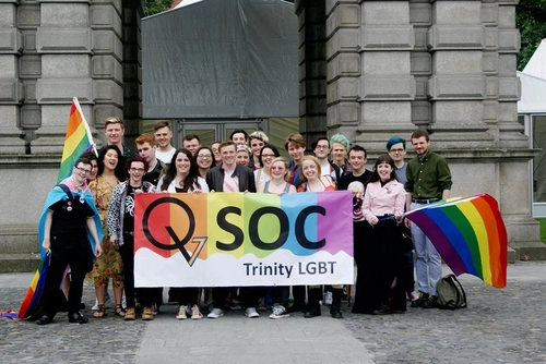Group of students from Trinity College LGBTQ society with rainbow banner