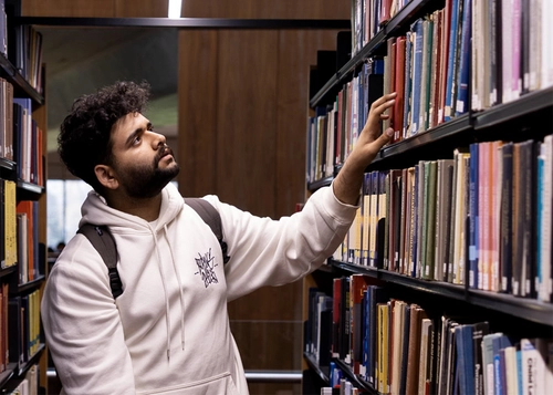 Student looking library shelves