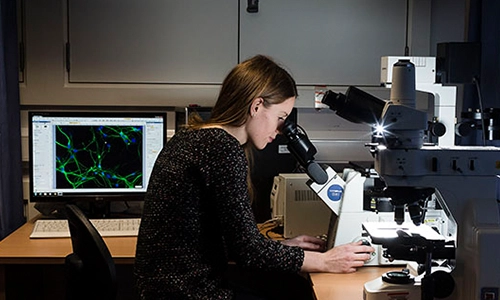 Woman looking into a microscope