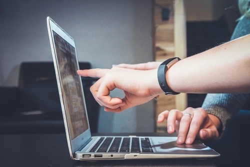 Person pointing at laptop