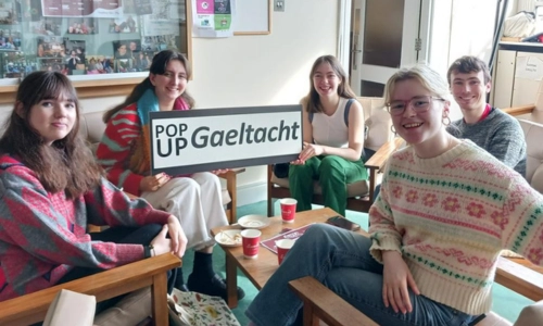 A group of Irish-speaking students holding a 'Pop Up Gaeltacht' sign.