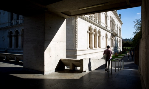 A student walking down a ramp from the Boland Library.