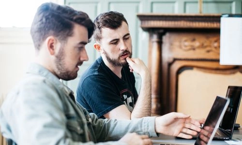 Two students seated at a laptop.