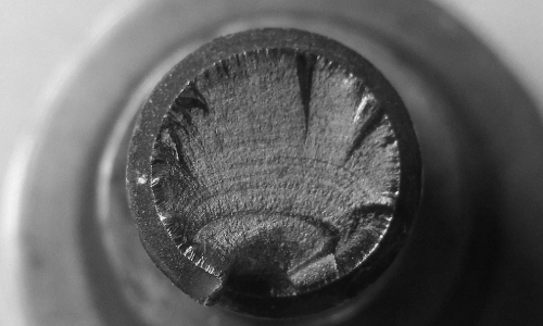 A close up image of a fractured and fatigued material