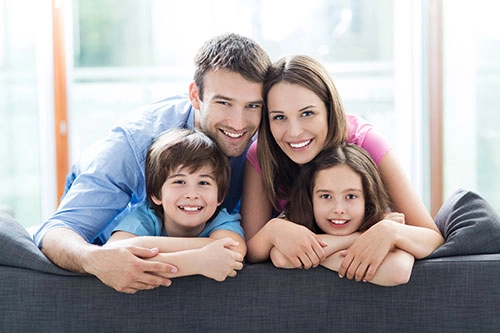 A family portrait: Two adults hugging two children