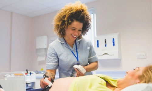 A pregnant woman getting a pregnancy scan speaking to the nurse