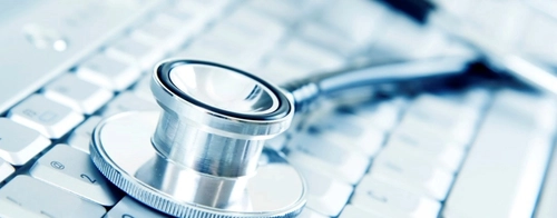 A stethoscope lying on keys of a keyboard