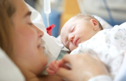 A mother holding her newborn child in hospital