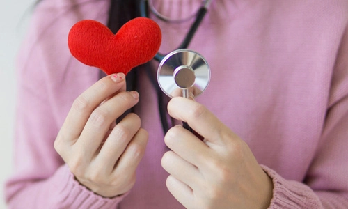 woman holding a stethoscope and cloth heart