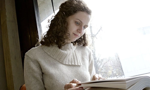 Student reading by a window