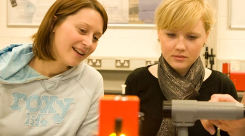 Image of two Physics students working on an experiment