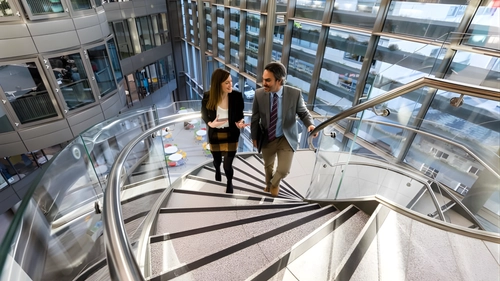 Two education professionals walking up a spiral staircase