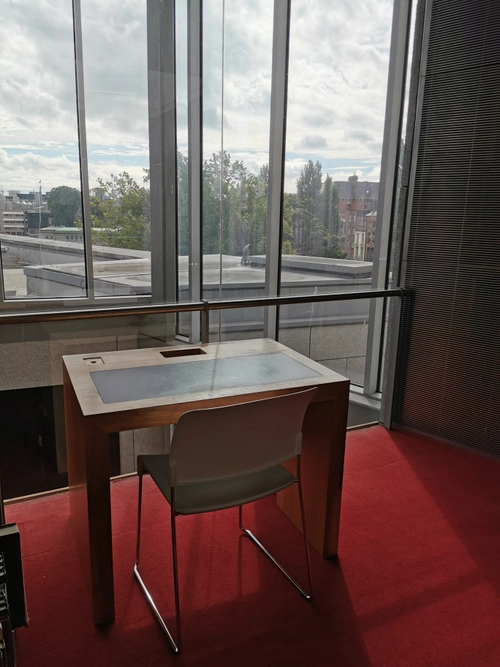 A desk on a high floor of a Trinity library, with a view of a roof