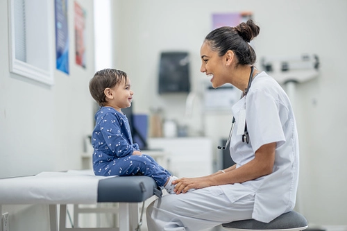Doctor examining child in hospital bed