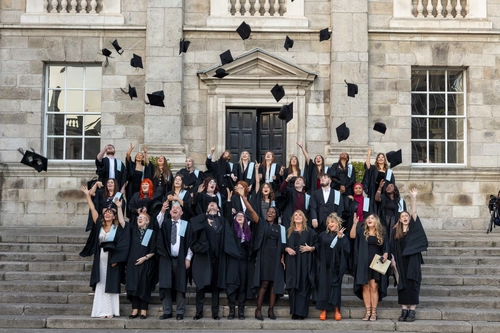 students throwing graduation caps in air
