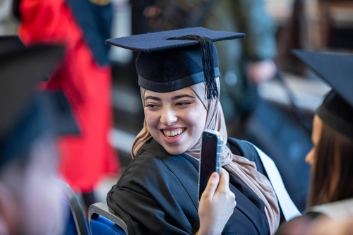 Young woman in cap and gown graduation