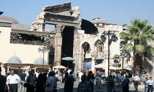 Image of a middle eastern building, that looks like a merge of a ancient ruin, supported by a modern sleek building.