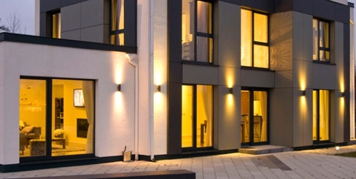 an image of an innovative house with lights on set in the evening