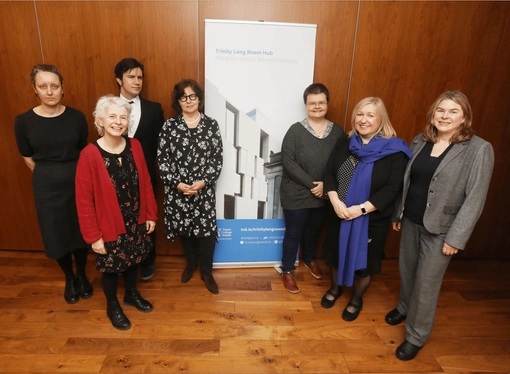 A group of people standing in front of a pull-up stand for the Trinity Long Room Hub