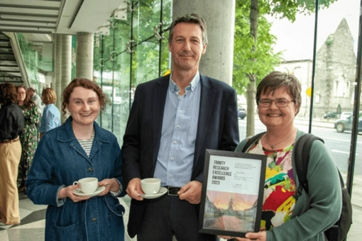 Dr Nina Sheil holding her award alongside Prof. Brian Broderick and Dr Siobhán O'Callaghan