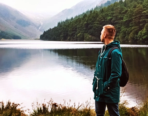 Person standing at Glendalough lake, Ireland.