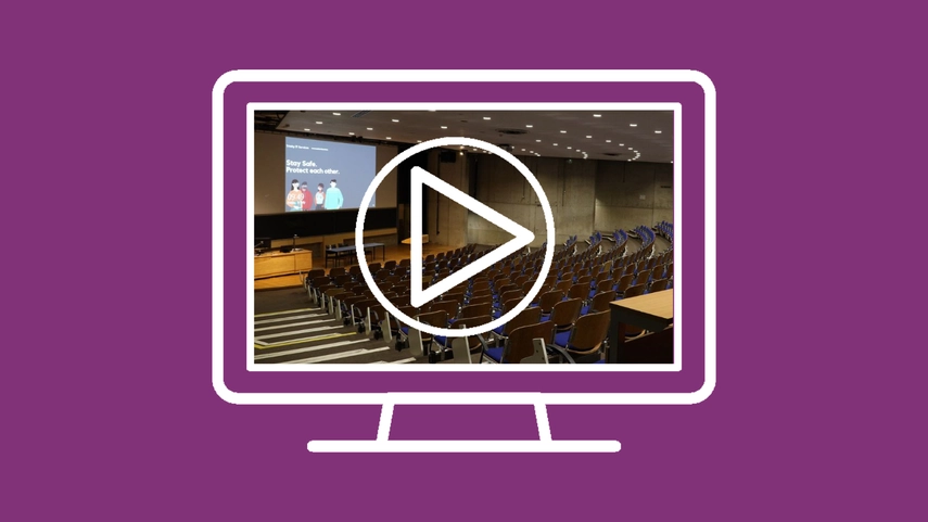 Icon of a computer screen with an image of a lecture theatre open on the screen with play button on top.