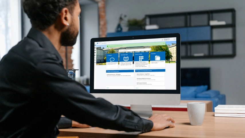 image of man at desk using the Trinity College Service Portal