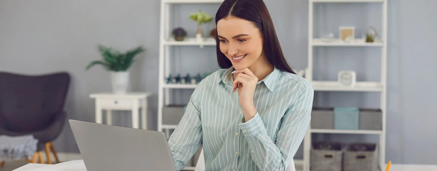 Woman looking into computer screen, smiling